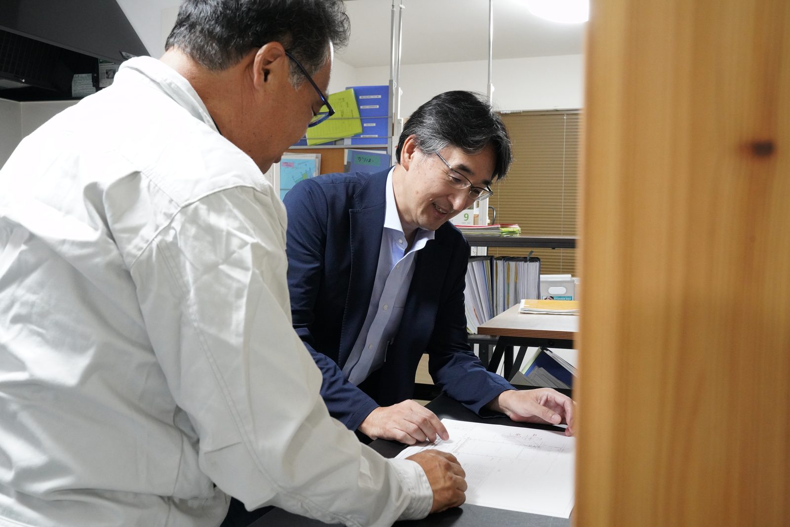 地主様と図面を確認しながら打ち合わせする土地家屋調査士